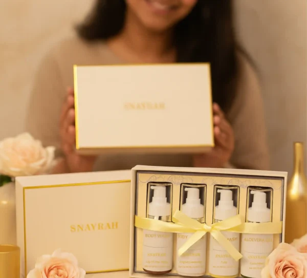 Cream SNAYRAH gift box with skincare bottles and pink roses, styled on white surface